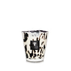 Vela en vaso de vidrio con estampado negro y dorado y etiqueta Baobab; mecha visible.