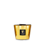 Vela en vaso de vidrio dorado con etiqueta Baobab Collection y cinta negra.