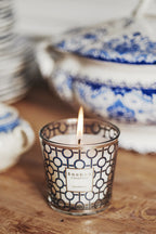 Vela Baobab con patrón azul en vaso de vidrio, llama encendida