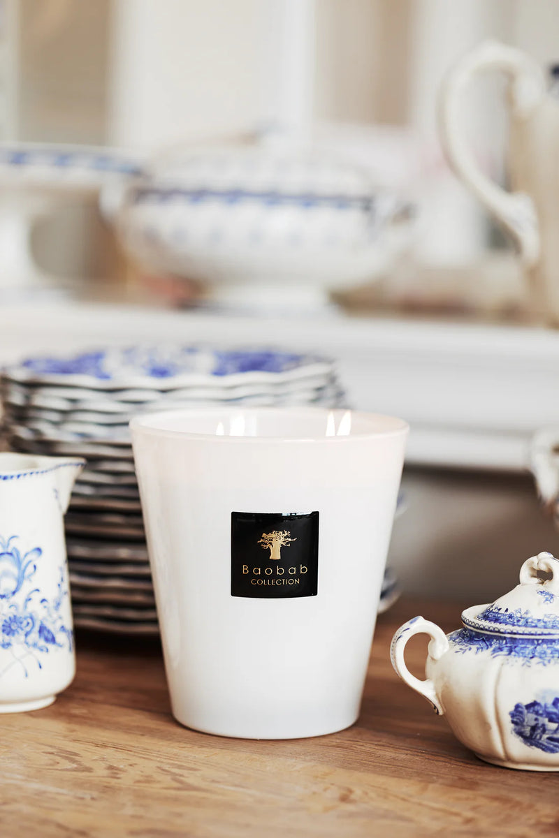 Vela Baobab en vaso blanco con etiqueta negra y árbol dorado.