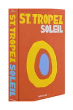 Libro St. Tropez Soleil con portada naranja, anillo amarillo y lomo con texto Assouline