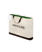 Bolsa de papel crema con texto ASSOULINE y borde verde en la parte superior