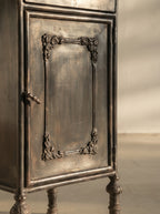 Mesita de noche de hierro negro con puerta decorativa y tirador metálico